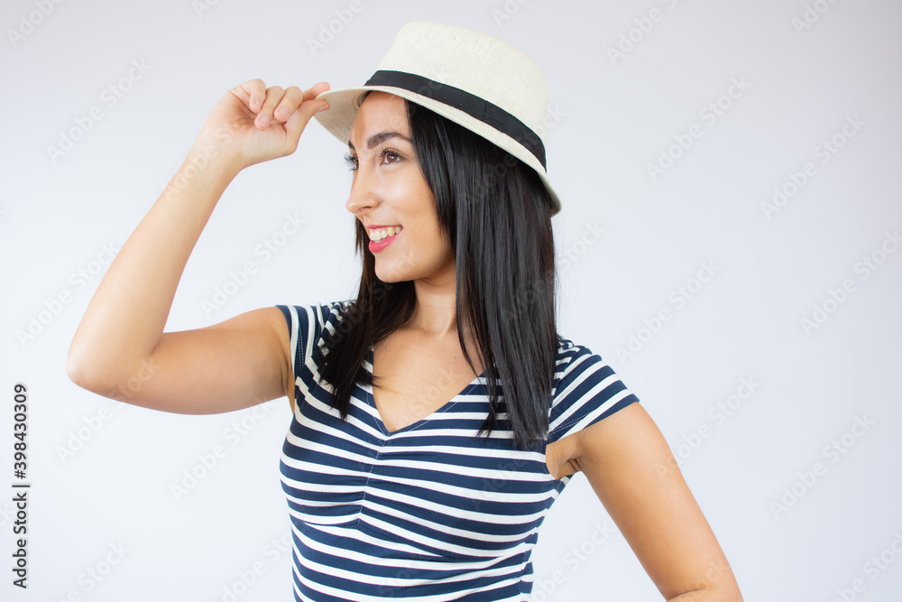 Young beautiful woman wearing straw hat and striped t-shirt smiling over white background. Young beautiful woman wearing straw hat and striped t-shirt smiling over white background.