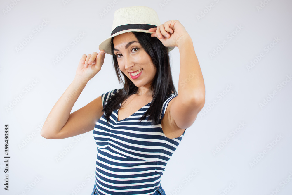 Young beautiful woman wearing straw hat and striped t-shirt smiling over white background. Young beautiful woman wearing straw hat and striped t-shirt smiling over white background.