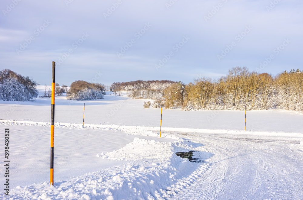 Snow poles at the edge of a country lane - Snow poles at the edge of a country lane in a winter scenery. Snow poles at the edge of a country lane - Snow poles at the edge of a country lane in a winter scenery.