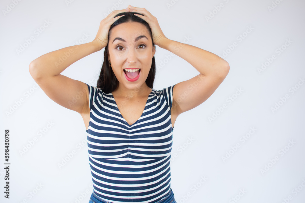 Close up portrait of young beautiful woman wearing striped t-shirt surprised with arms on head over white background. Close up portrait of young beautiful woman wearing striped t-shirt surprised with arms on head over white background.