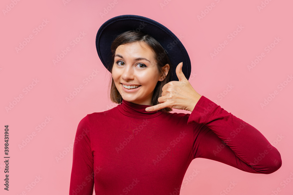 Pretty girl shows gesture call the phone, standing on pink background. People, body language concept. Pretty girl shows gesture call the phone, standing on pink background. People, body language concept.