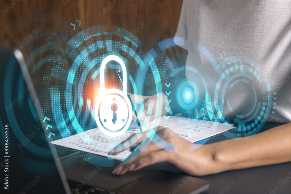 Businesswoman typing on computer in office. Lock icon hologram. Security concept. Double exposure. Businesswoman typing on computer in office. Lock icon hologram. Security concept. Double exposure.
