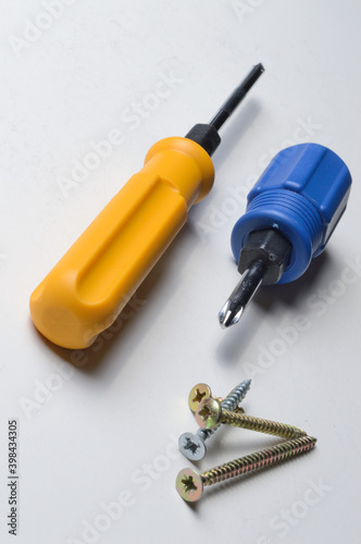 two different screwdrivers and several screws on a white background. close-up.