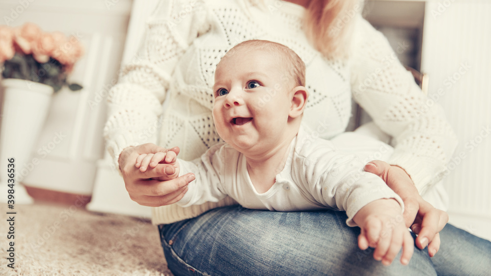 Fototapeta premium mother with baby sitting near the fireplace in a cozy living room