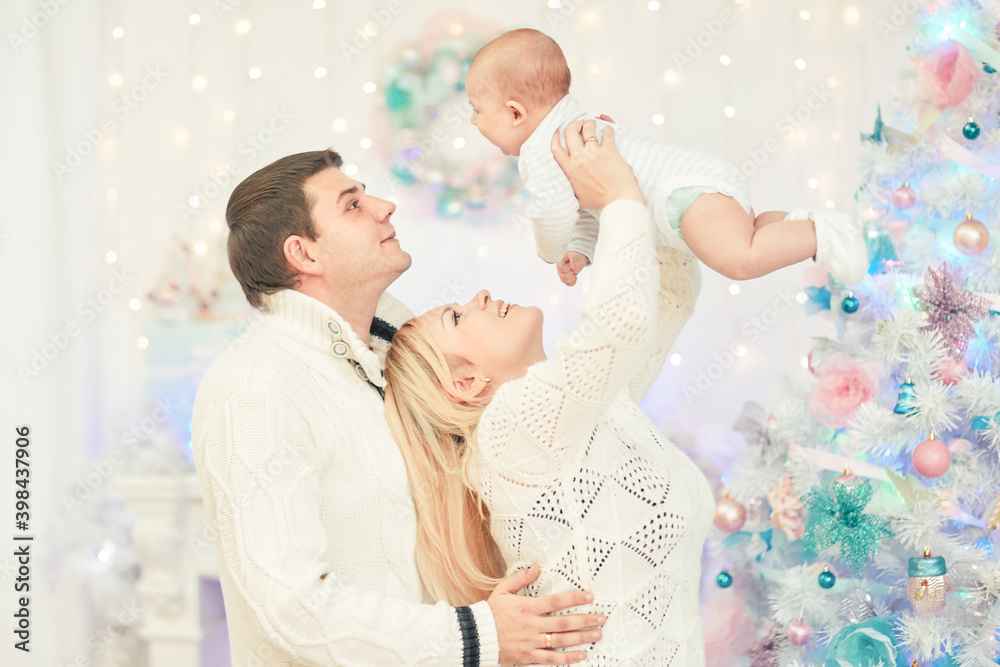 loving parents with play with their baby standing in the festive living room loving parents with play with their baby standing in the festive living room