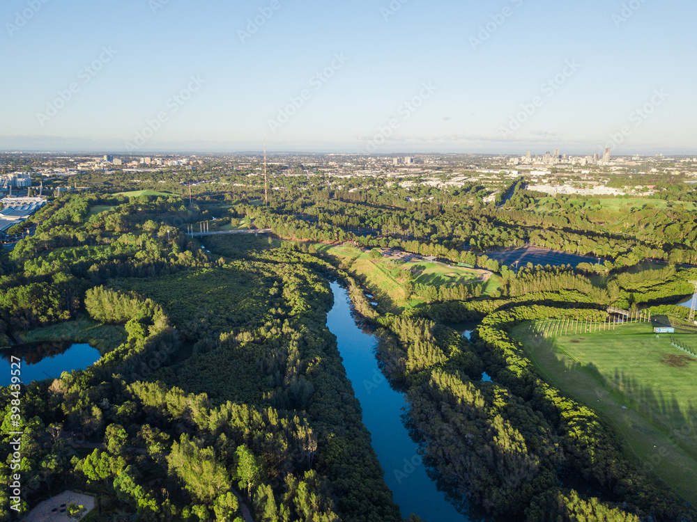 Aerial view of scenic green with small river in the middle.