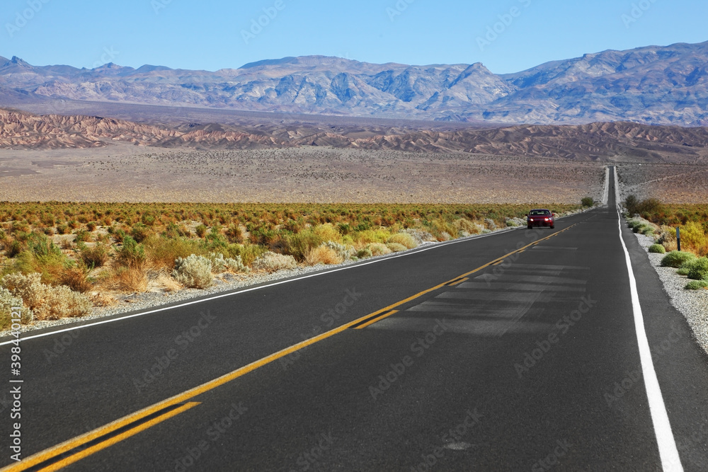 The red car traveling on the road