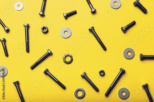 Bolts and nuts closeup on yellow background.