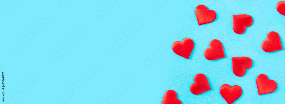 Red hearts on blue background. Panorama view. Copy space