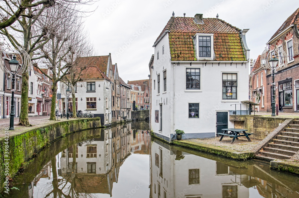 Oudewater, The Netherlands, December 6, 2020: picturesque view from the cantral square towards historic houses reflecting in the mirror-like water of Lange Linschoten canal