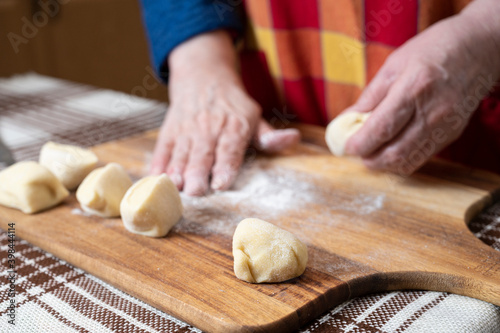 Woman preparing dough for manti with minced beef meat