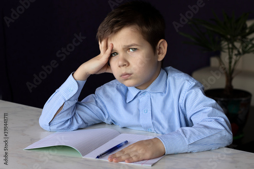 boy with copybook. the child is sitting for lessons photo