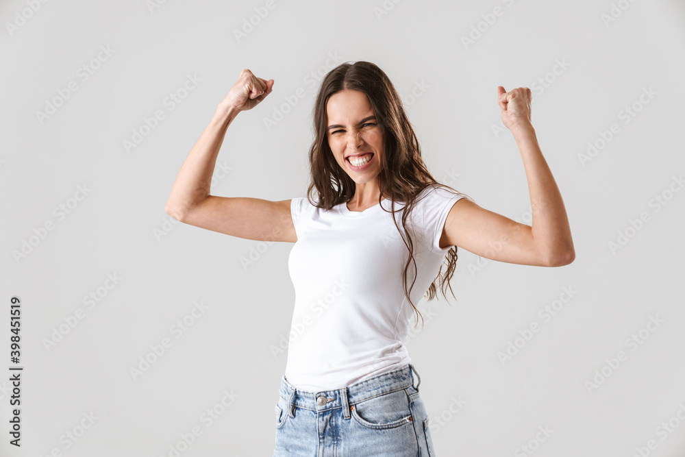 Excited beautiful girl smiling and making winner gesture Excited beautiful girl smiling and making winner gesture