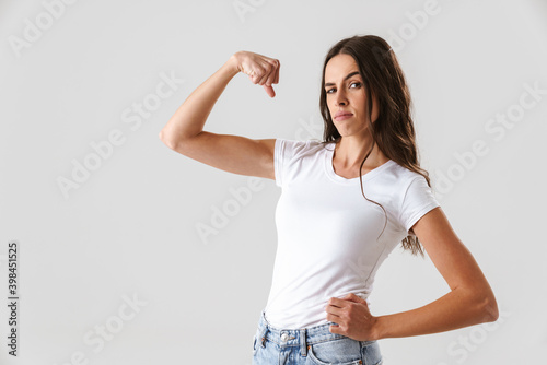Photographie Pleased beautiful girl showing her bicep at camera