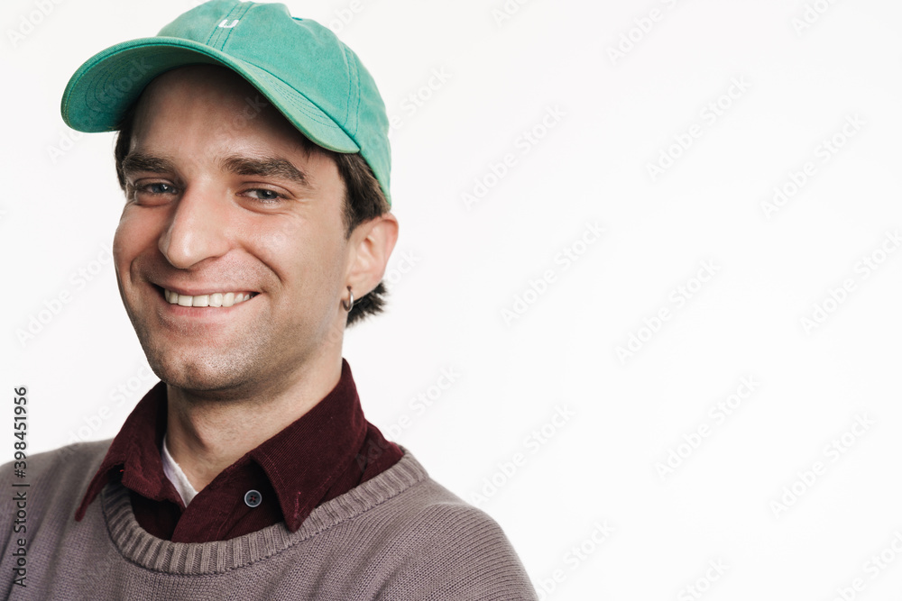 Young happy man in cap smiling and looking at camera Young happy man in cap smiling and looking at camera