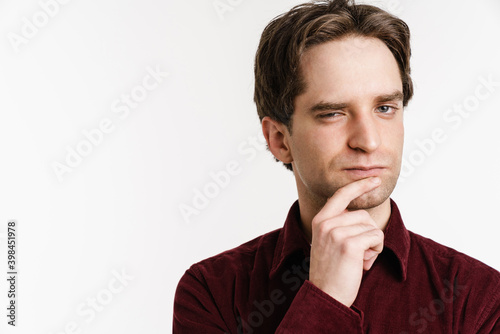 Handsome puzzled young man posing and looking at camera