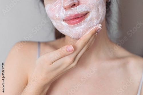 Fotografie The girl applies cream to her face