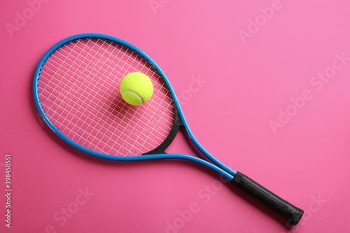Tennis racket and ball on pink background, top view. Sports equipment © New Africa