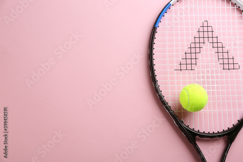Tennis racket and ball on pink background, top view. Space for text © New Africa
