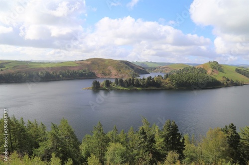 A panoramic view across the tree lined foreshore of Llyn Clywedog in Powys, Wales.
