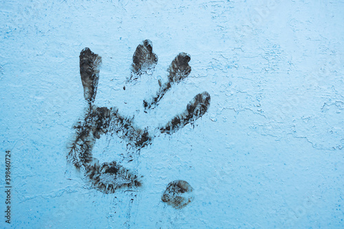 left hand print on a blue wall