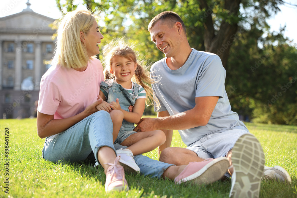 Happy parents with their child having fun on green grass. Spending time in nature Happy parents with their child having fun on green grass. Spending time in nature