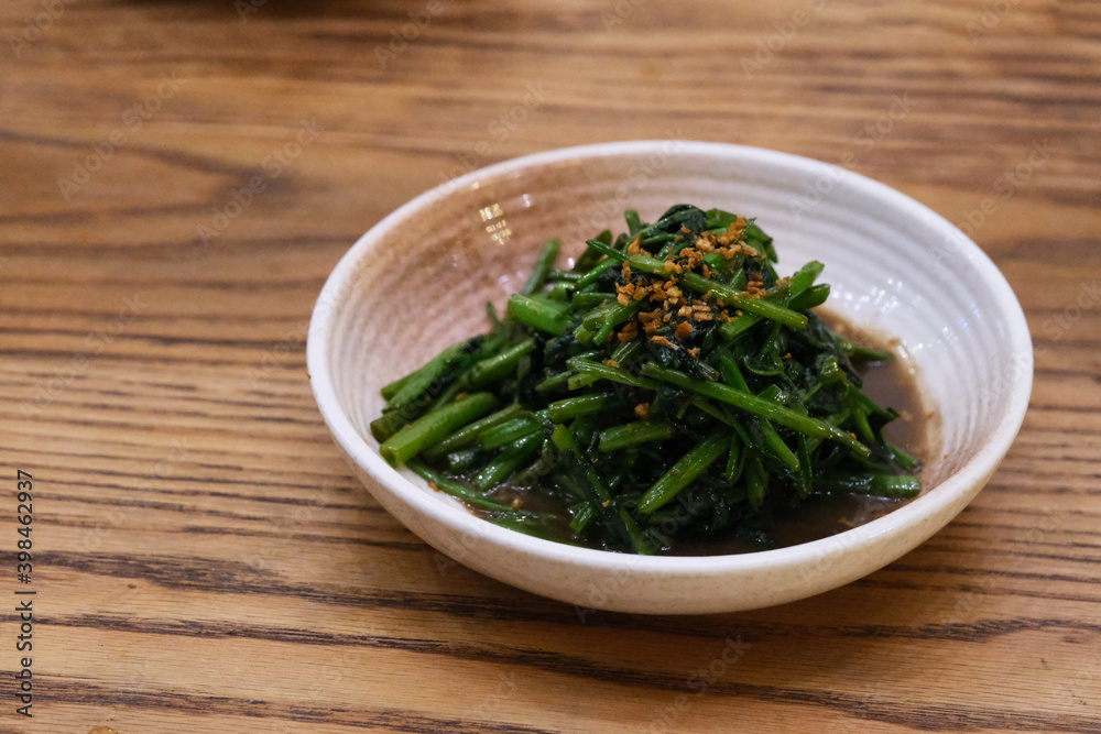 close up shrimp paste water spinach in plate on patterned wooden table. Traditional Thai food close up shrimp paste water spinach in plate on patterned wooden table. Traditional Thai food