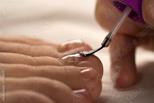 Applying nail polish on toe nails  close up.