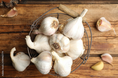 Fresh organic garlic in basket on wooden table  flat lay
