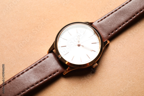 Luxury wrist watch on beige background, closeup