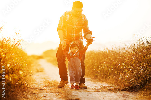 Child pilot aviator with airplane dreams of traveling in summer in nature at sunset，Happy kid playing with father. Dad and son outdoors.