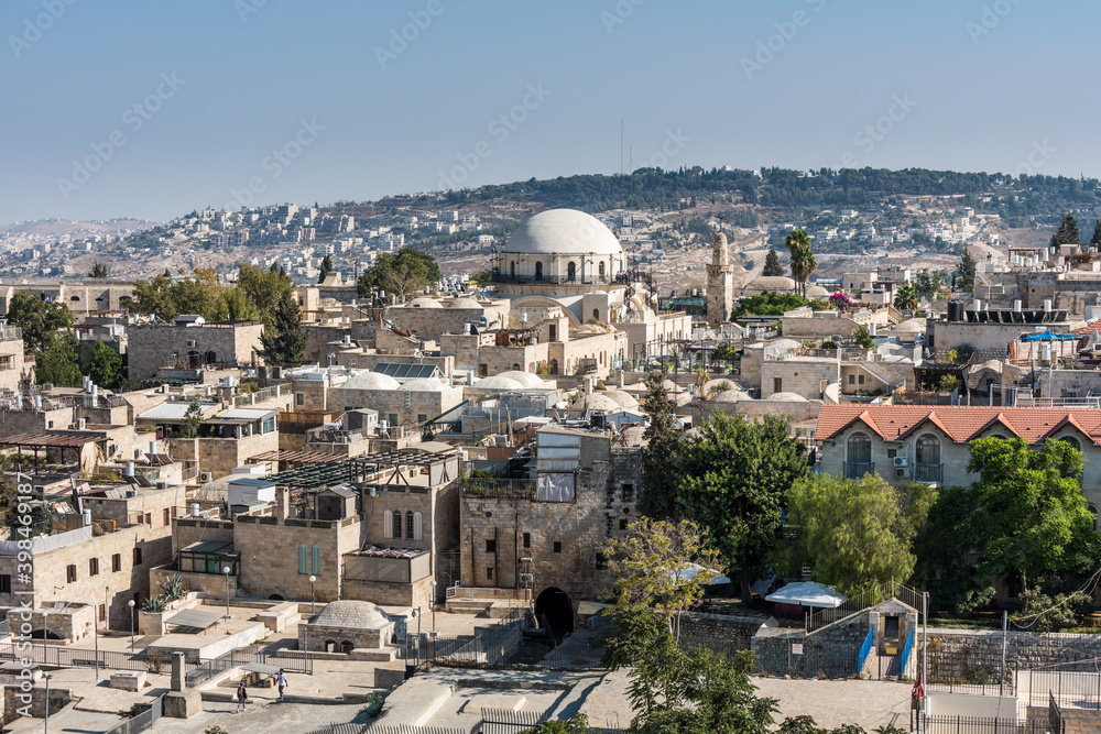 Aerial view of rooftops of traditional buildings and Hurva Synagogue in the old city with blue sky of Jerusalem. View from the Lutheran Church of the Redeemer.