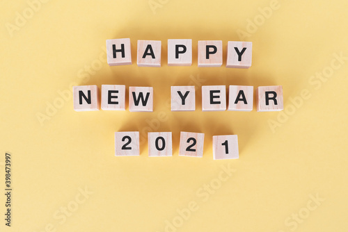 Happy New Year 2021 on wooden block yellow background