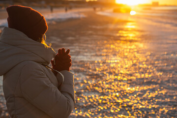 Young woman winter enjoying winter sun. Red sunset light. Winter solstice.