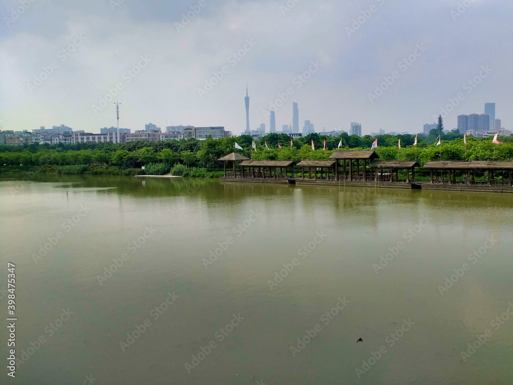 A view of skyscrapers in the distance. CBD, city center. River in the park. Guangzhou. Guangdong. China. Asia