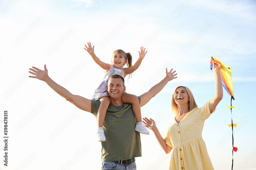 Happy parents with their child playing with kite on beach. Spending time in nature Happy parents with their child playing with kite on beach. Spending time in nature