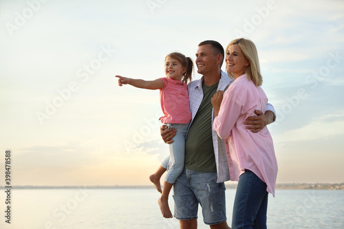 Happy parents with their child on beach. Spending time in nature