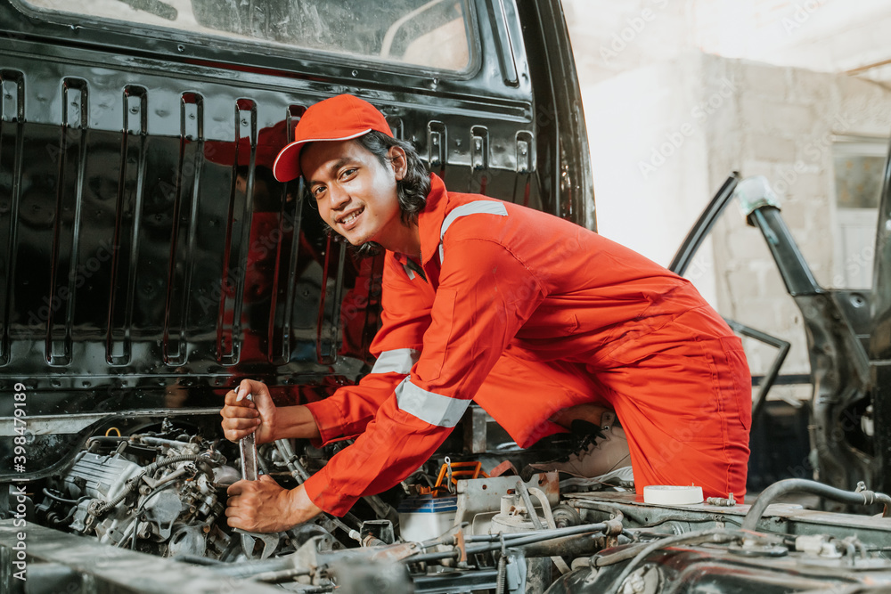 portrait of young asian man repairing a broken car engine part