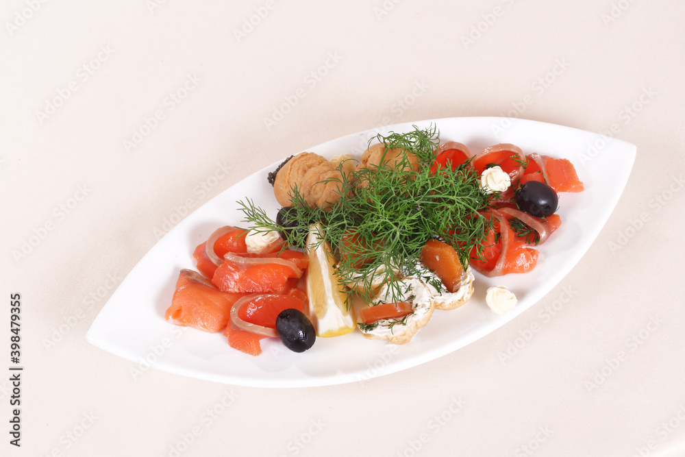 Slices of red fish on a plate with olives, lemon, dill and white sauce Slices of red fish on a plate with olives, lemon, dill and white sauce