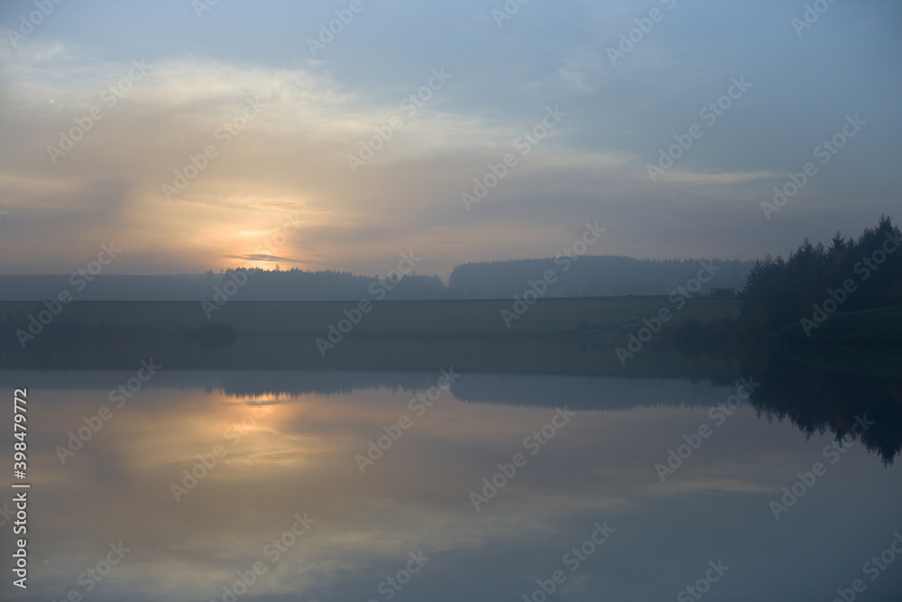 Dusk sunset over redmires reservoirs with hazy and calm conditions