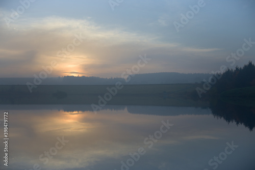 Dusk sunset over redmires reservoirs with hazy and calm conditions