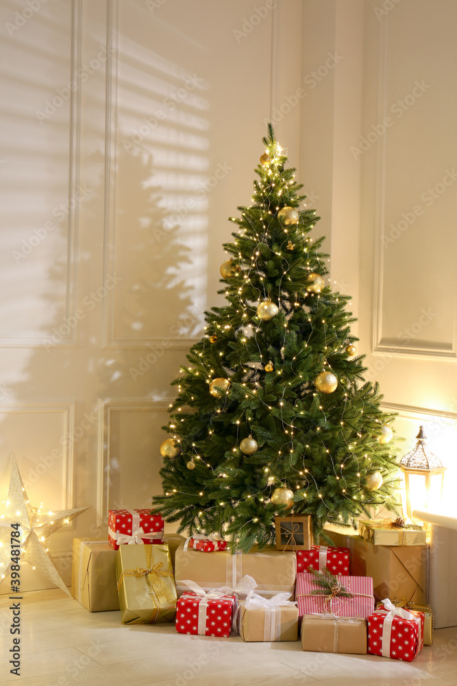 Gift boxes under Christmas tree with fairy lights indoors Gift boxes under Christmas tree with fairy lights indoors