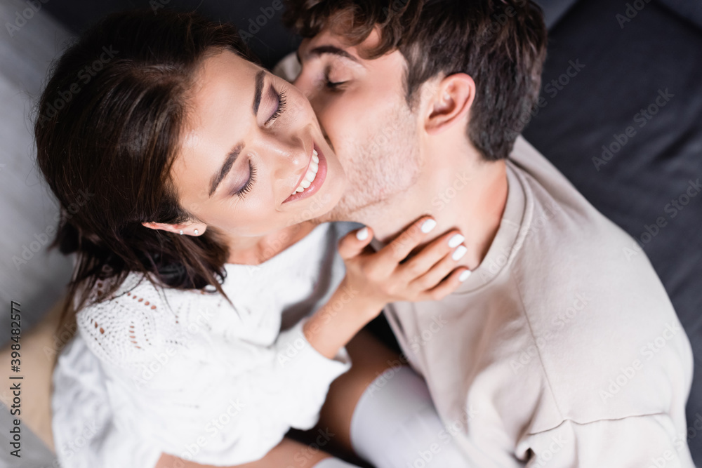 Overhead view of man kissing smiling girlfriend at home Overhead view of man kissing smiling girlfriend at home