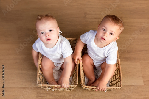 Foto twin boys sitter. twin brothers at the age of one year old