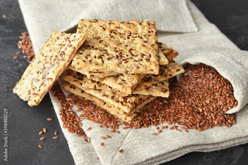 Fotografi Stack of multigrain crispbread with flax seeds on linen napkin background
