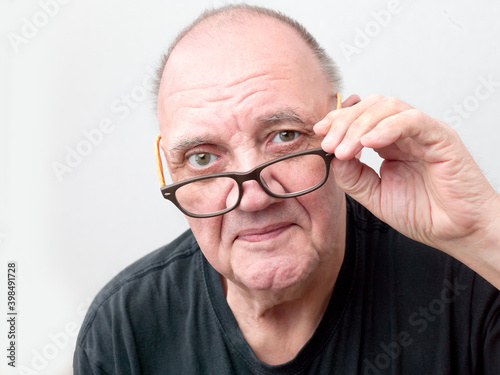 portrait vieil homme regardant par dessus ses lunettes