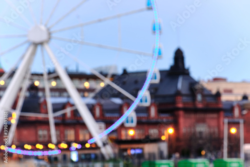 Obraz na płótnie Blurred view of Ferris wheel and historical neighborhood of Helsinki in the evening. w salonie