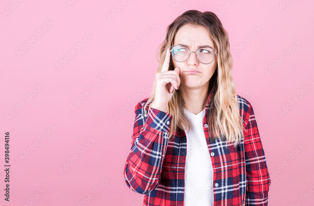 Portrait of young woman thinking with her finger to her head and looks to the side