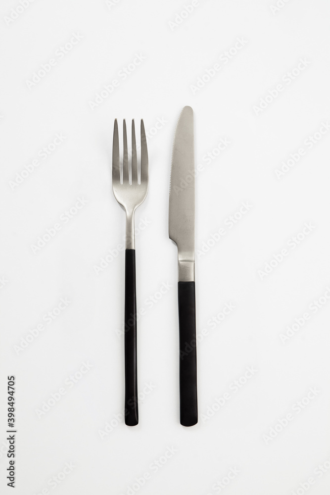 Black silver or steel cutlery view from above on a white background. Top view..Knife and fork for a festive table for a wedding, birthday or party. Black silver or steel cutlery view from above on a white background. Top view..Knife and fork for a festive table for a wedding, birthday or party.