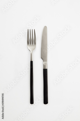 Black silver or steel cutlery view from above on a white background. Top view..Knife and fork for a festive table for a wedding  birthday or party.